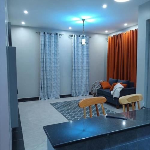 a living room with a couch and two chairs at Alo's Apartment_KISASI in Kampala