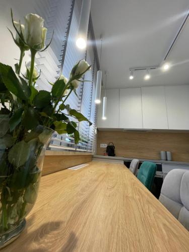 um vaso com uma rosa branca sentada numa mesa em LM Axis Apartment em Kielce