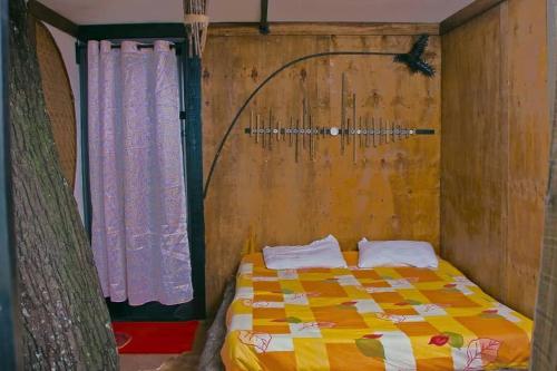 a bedroom with a bed and a curtain at Ragu Farm Eco Nest in Kalangala