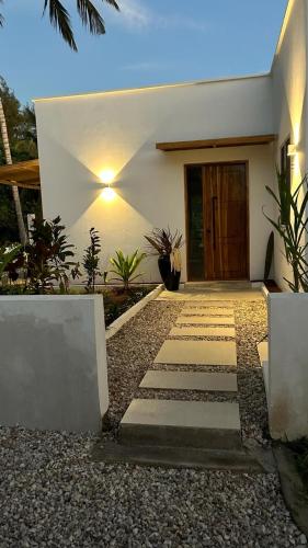 a house with a pathway leading to the front door at Villa Shepherd Zanzibar - LUXURY BEACH FRONT - KIWENGWA in Kumba Urembo
