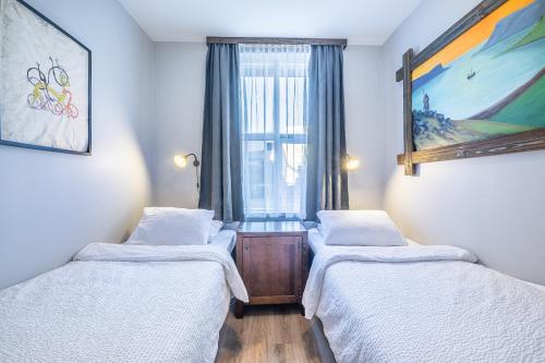 two beds in a room with a window at Hotel Viking in Hafnarfjördur