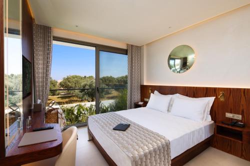 a bedroom with a bed and a large window at Voger Alaçatı Prive in Cesme