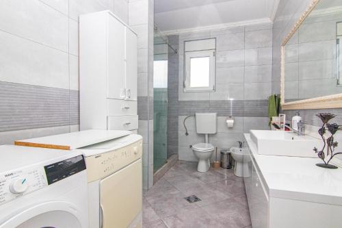 Baño blanco con lavabo y aseo en Deluxe Holiday Home-Podgorica en Podgorica