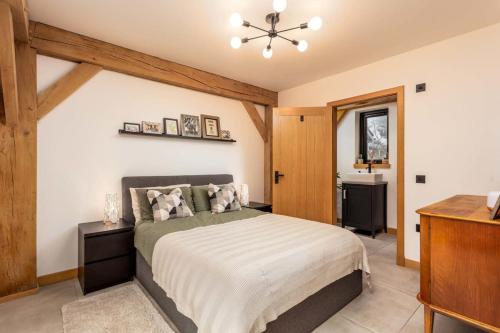 a bedroom with a large bed and a dresser at Windhover Barn in Annbank