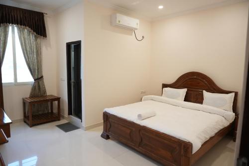 a bedroom with a bed with white sheets and a window at SABA SERVICE APARTMERNT in Hyderabad