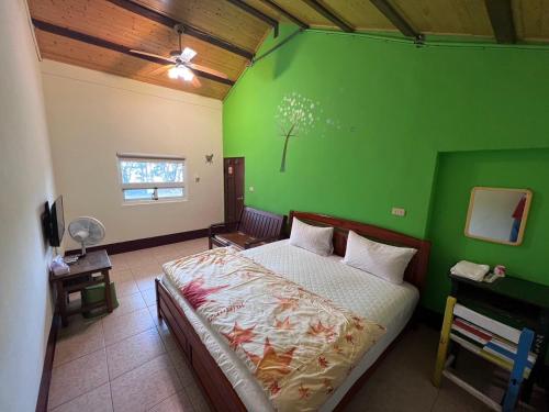 a bedroom with a green wall with a bed at Color Rainbow Home in Taimali