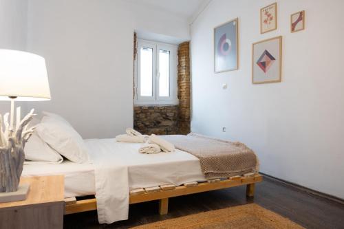 1 dormitorio con 1 cama con toallas en Port loft, en Mantoúkion