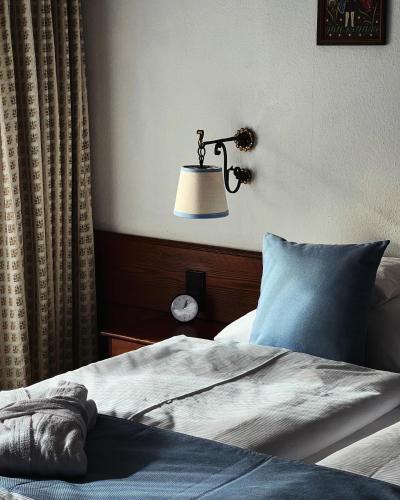 ein Schlafzimmer mit einem Bett und einer Wandlampe in der Unterkunft Boutique Hotel Dorer in Schönwald