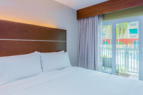 1 dormitorio con cama y ventana grande en Holiday Inn Express Hotel & Suites Bradenton West, an IHG Hotel, en Bradenton