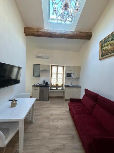 un salon avec un canapé rouge et une table dans l'établissement Studio familial a Mezzanine presbytère dans l'Église, à Narbonne