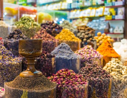 a display of different colored spices in a market at Novotel Dubai Gold District in Dubai