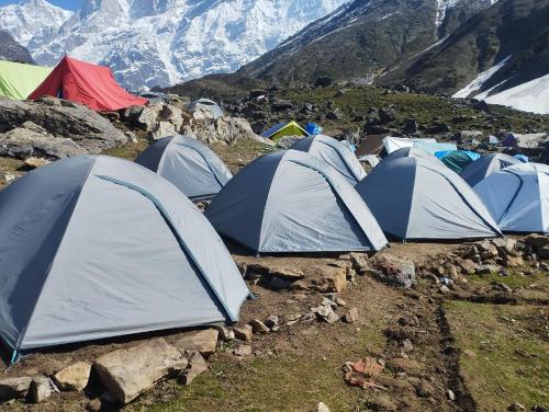 un grupo de tiendas de campaña en una montaña con montañas en el fondo en Rajwan peradise tents en Kedārnāth
