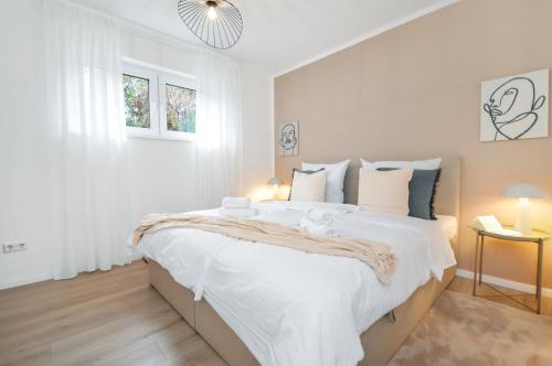 a white bedroom with a large bed with white sheets at Stil und Komfort - Terrasse - Internet in Bielefeld