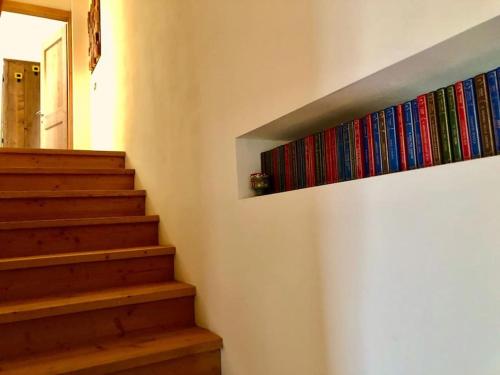 a staircase with colorful books on a wall at L'Oretta Moena Fata delle Dolomiti in Moena