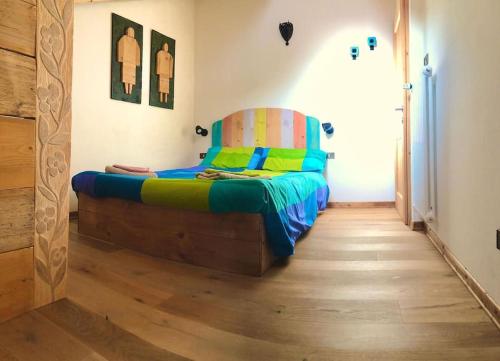 1 dormitorio con 1 cama y suelo de madera en L'Oretta Moena Fata delle Dolomiti, en Moena