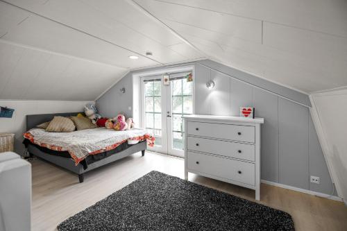 a bedroom with a bed and a dresser and a window at Kerava talo in Kerava