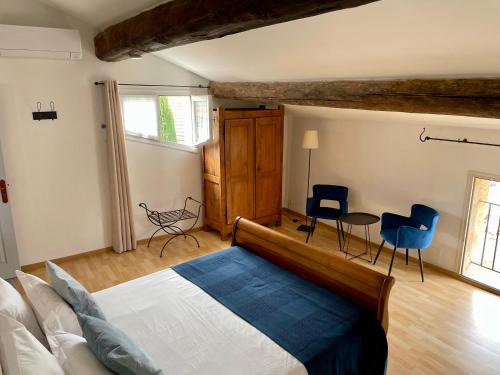 1 Schlafzimmer mit einem Bett, 2 Stühlen und einem Tisch in der Unterkunft Villa Velleron in Velleron