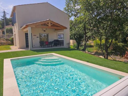a swimming pool in front of a house at Maison en Provence avec piscine in Sainte-Tulle