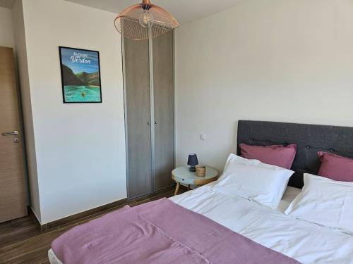 a bedroom with a bed with pink and white pillows at Maison en Provence avec piscine in Sainte-Tulle