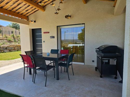 a patio with a table and chairs and a grill at Maison en Provence avec piscine in Sainte-Tulle