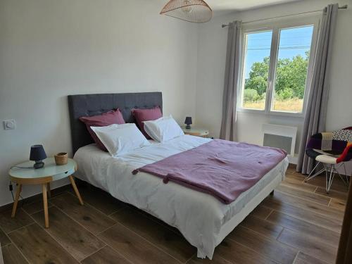 a bedroom with a large bed with a purple blanket at Maison en Provence avec piscine in Sainte-Tulle