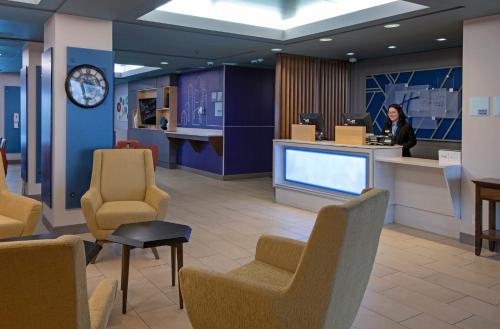 a woman standing at a counter in a waiting room at Holiday Inn Express Kamloops by IHG in Kamloops