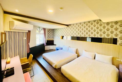 a hotel room with two beds and a desk at 南天海旅店 in Hengchun