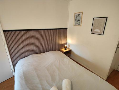 a bedroom with a white bed and a side table at MÂCON HYPER CENTRE - GARE in Mâcon