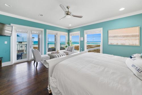 a bedroom with a large white bed and views of the ocean at La Luna in Santa Rosa Beach