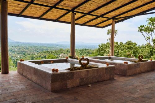 a large stone tub on a patio with a view at Sumberkima Hill Retreat in Pemuteran