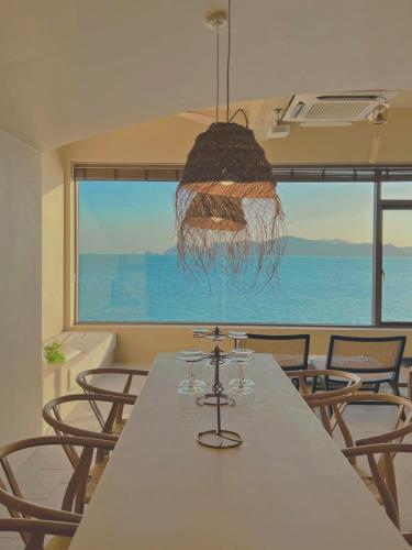 a dining room with a table with chairs and a large window at Banwol Poolvilla in Busan