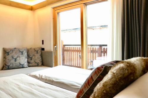 a hotel room with a bed and a large window at Hotel Galli's - Centro in Livigno
