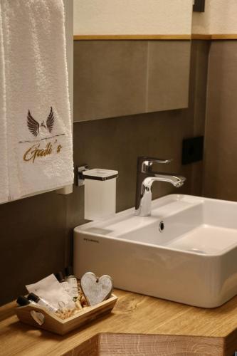 a bathroom with a white sink and a towel at Hotel Galli's - Centro in Livigno