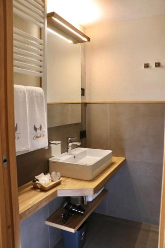 a bathroom with a white sink and a mirror at Hotel Galli's - Centro in Livigno