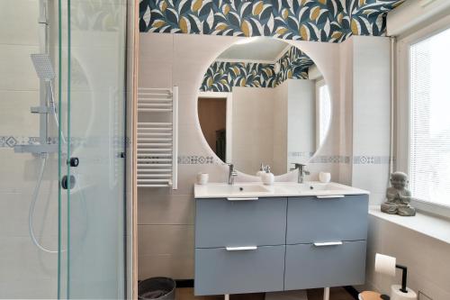 a bathroom with a sink and a mirror at Villa Mi-Syl- Jolie maison en pierre à Quévert in Quévert