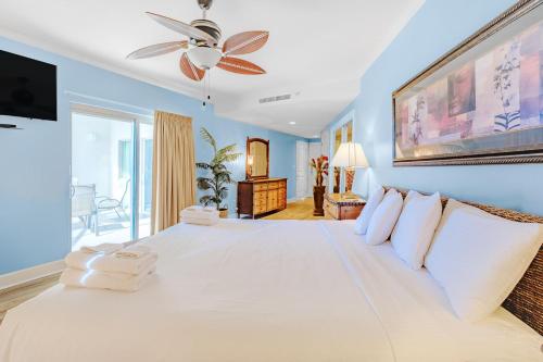 1 dormitorio con 1 cama blanca grande y ventilador de techo en Sea Breeze 508, en Gulfport