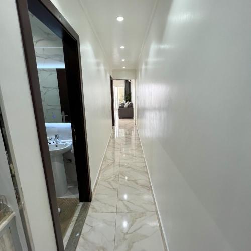 a hallway with a sink and a mirror at Almasarat Tower Sea View in Jeddah