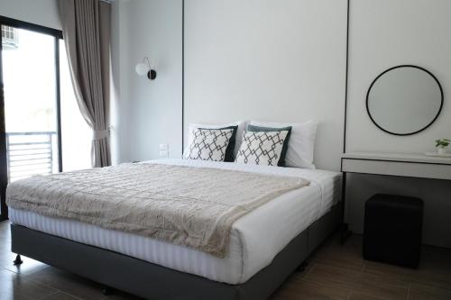 a bedroom with a large bed with a mirror on the wall at VIYA Residence in Ban Phala