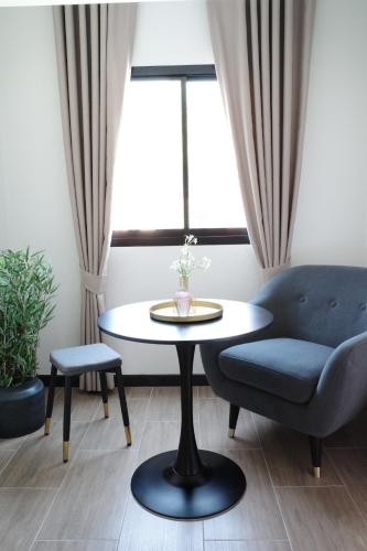 un soggiorno con tavolo e divano blu di VIYA Residence a Ban Phala