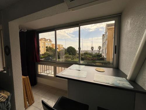 Cette chambre avec vue dispose d'une fenêtre et d'un bureau. dans l'établissement Appartement proche du port à Gruissan, à Gruissan