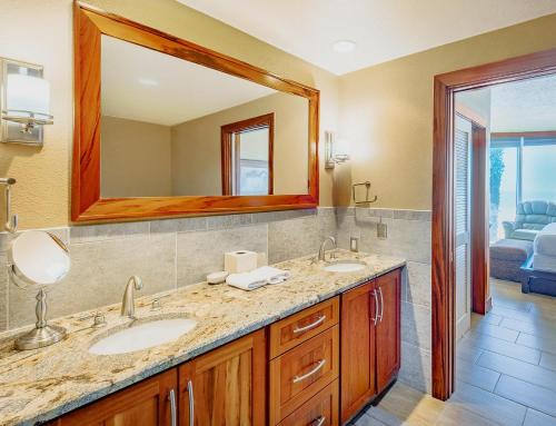 a bathroom with two sinks and a large mirror at Ocean Club 105 Deluxe in Biloxi