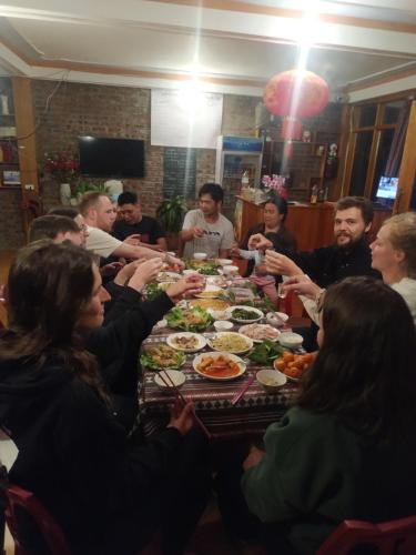 Un groupe de personnes assises autour d'une table et mangeant de la nourriture dans l'établissement Salem House Sapa, à Lào Cai