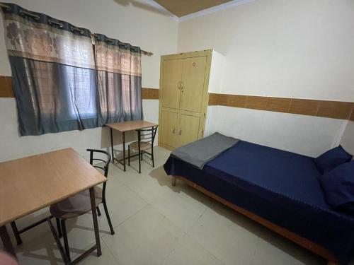 um quarto com uma cama, uma mesa e cadeiras em Omjee Paying Guest em Dehradun