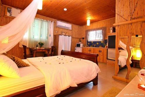 1 dormitorio con 2 camas y TV en una habitación en ביקתפוז וקלמנטינה- מתחם בקתות וסוויטות עם ג'קוזי פרטי ובריכה משותפת, en Liman