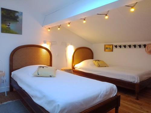 une chambre avec deux lits dans une pièce dans l'établissement La maison bleue de St Pierre, à Saint Pierre La Mer