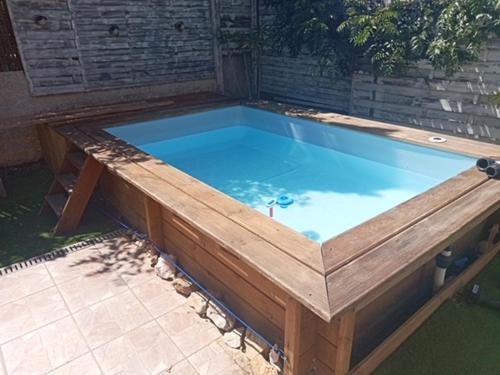 un bain à remous avec une terrasse en bois et une piscine bleue dans l'établissement La maison bleue de St Pierre, à Saint Pierre La Mer