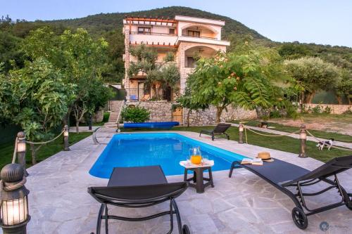 a villa with a swimming pool in front of a house at Villa Marco Polo with swimming pool in Budva