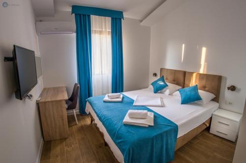 una camera da letto con un grande letto con lenzuola blu e cuscini blu di Villa Marco Polo with swimming pool a Budua