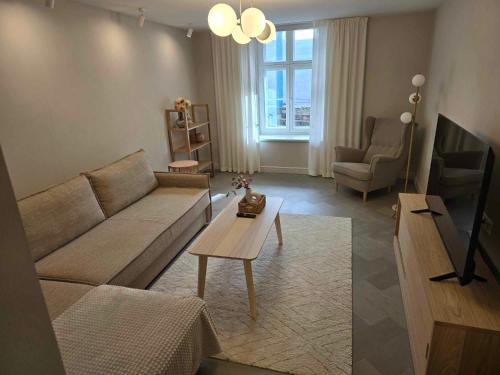 a living room with a couch and a table at Augusta Christina, Güldenstubbe Residences in Kuressaare