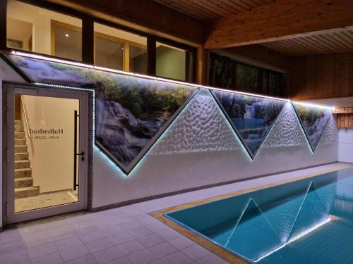 a swimming pool in a building with a painting on the wall at Berggasthof Zottensberg in Edlbach